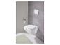 WC suspendu blanc avec bouton de chasse d'eau et tapis vert.