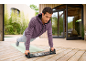 Homme faisant des pompes sur une planche à pompes en extérieur.