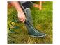 Boots et tuyau d'arrosage vert utilisés pour nettoyer des bottes.