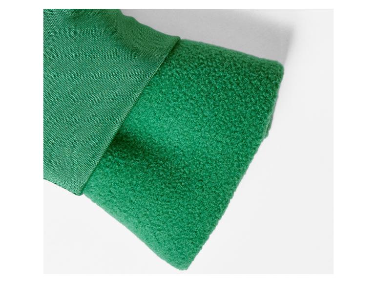 Détail de la manche d'une veste verte avec un tissu double couche.