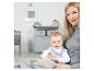Mère et bébé dans une chambre d'enfant avec des meubles et accessoires gris.