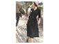 Une femme porte une robe noire avec une ceinture et un chapeau, tandis qu'un homme porte un t-shirt avec un imprimé d'avion.