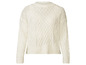 Un pull blanc en maille torsadée.