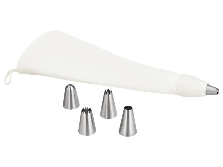 Poche à douille blanche avec quatre douilles de décoration métalliques différentes.