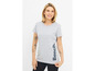 Une femme porte un t-shirt gris avec le logo Bench.