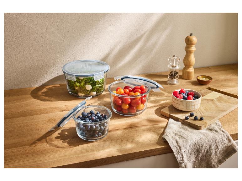 Récipients en verre avec des aliments frais sur un comptoir en bois.