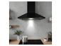 Hotte de cuisine noire au-dessus d'une plaque à induction avec casserole et café.