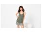 Femme souriante en débardeur vert olive et short de pyjama à imprimé floral.