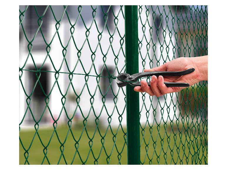 Installation d'une clôture en grillage vert avec des outils de fixation.