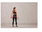 Une femme en vêtements de sport avec un bande de résistance rose