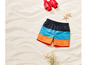 Short de bain d'été avec des rayures bleues et orange sur du sable blanc.
