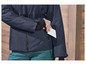 Une veste bleu marine avec une ceinture, des poches et une fermeture éclair.