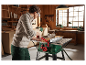 Une femme utilise une scie à table Parkside dans son atelier.