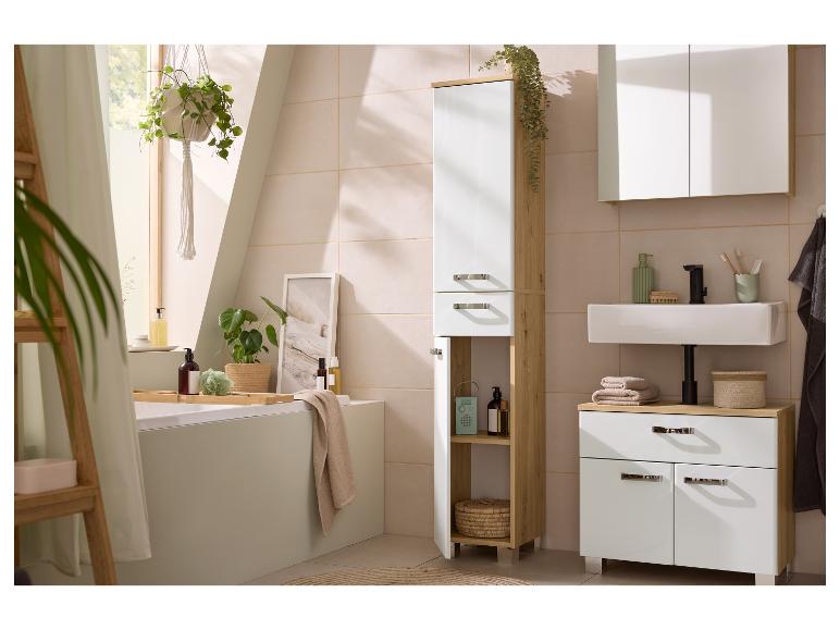 Salle de bain lumineuse avec meubles en bois et blancs, plantes et baignoire.