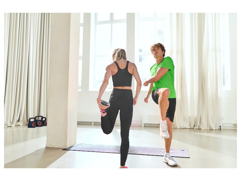 Deux personnes s'étirent sur des tapis de yoga, vêtues de vêtements de sport.