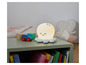 Une lampe de nuit en forme de pieuvre sur une table de chevet avec des jouets et des livres.