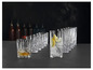 Un verre de whisky et un verre de gin avec de la glace et du citron dans une rangée de verres.