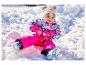 Un tout-petit en pantalon de neige rose LUPILU® s'amuse dans la neige.