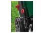 Détail d'une tondeuse à gazon verte avec roues noires et réglage de hauteur rouge sur l'herbe.
