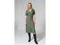 Un mannequin porte une robe verte et des bottes de cow-boy noires.