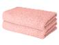 Deux serviettes roses soigneusement pliées et empilées l'une sur l'autre