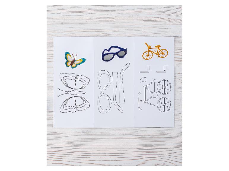 Un papillon, des lunettes de soleil et un vélo, avec leurs modèles, sur une table en bois.