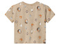 T-shirt beige imprimé de croissants, fruits et un panier rempli de pain.