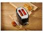 Grille-pain rétro noir avec des tartines et de la confiture sur un plan de travail en bois.