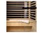 Intérieur d'un sauna en bois avec une serviette blanche sur le banc et une porte vitrée.