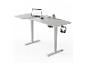 Bureau assis-debout gris avec ordinateur portable, souris, tasse, plante et casque.