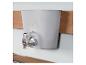 Distributeur d'eau mural gris avec robinet chromé, sur fond de bois et de mur clair.