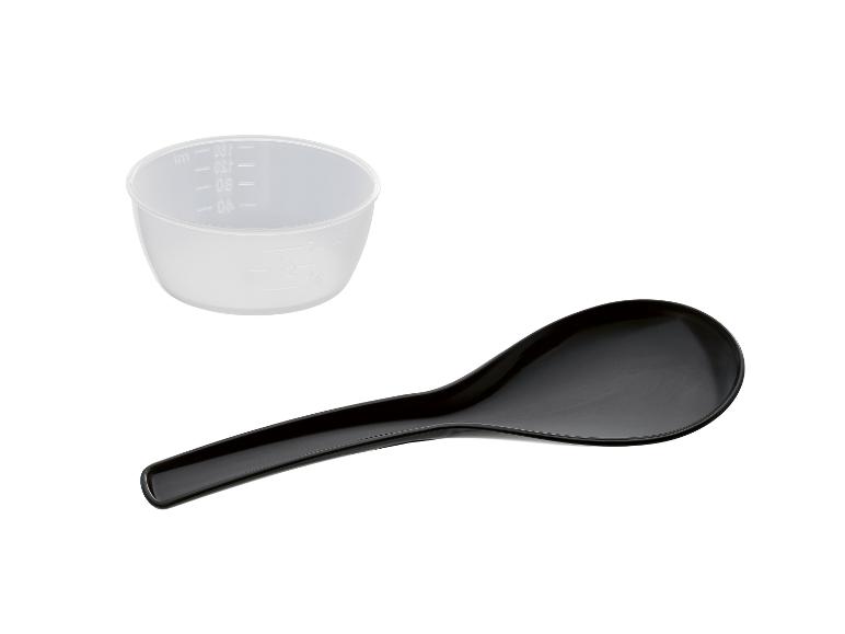 Tasse à mesurer le riz et cuillère de service noire pour le riz sur fond blanc.