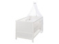 Lit bébé blanc avec ciel de lit et draps à étoiles