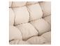 Détail de coussins matelassés beiges avec une texture de tissu.