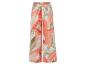 Pantalon large à motif floral, couleurs corail et vert.