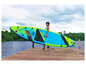 Une femme porte une planche de paddle gonflable de la marque Aqua Marina.
