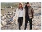 Une femme et un homme portant des vestes d'hiver marchent sur une berge rocheuse.