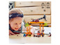 Un enfant joue avec un ensemble LEGO® avec une grue, des pirates et un requin.