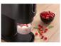 Appareil de cuisine noir avec framboises et lait, sur une surface en bois.