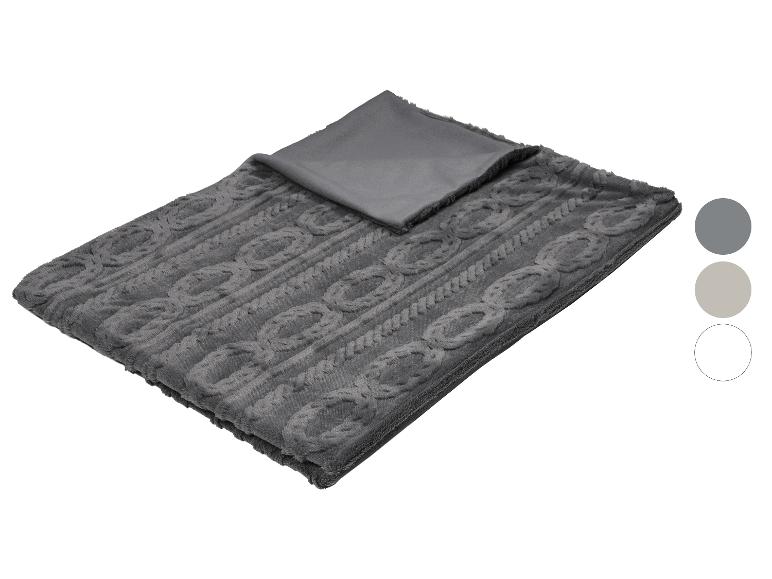 Une couverture grise texturée en tricot torsadé avec un dessous gris lisse, présentée avec des échantillons de couleurs.