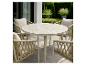 Ensemble de salle à manger d'extérieur avec table ronde et quatre chaises tressées sur une terrasse.