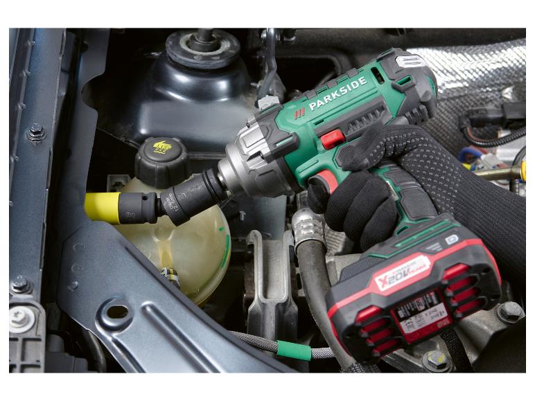 Visseuse à chocs PARKSIDE X 20V Team utilisée sur un moteur de voiture.