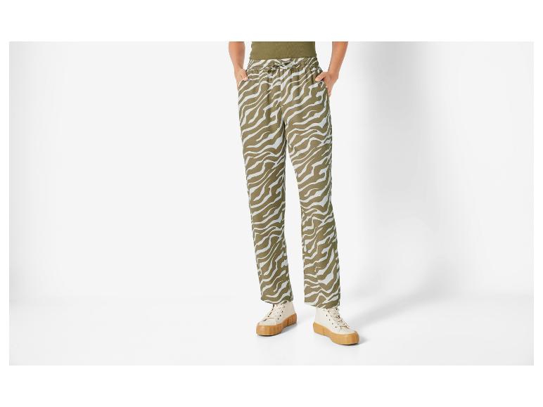 Pantalon à motif zèbre et baskets blanches.