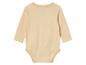 Un body bébé à manches longues de couleur beige clair.