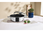 Casserole en acier inoxydable avec couvercle en verre, brocoli et épices sur une table.