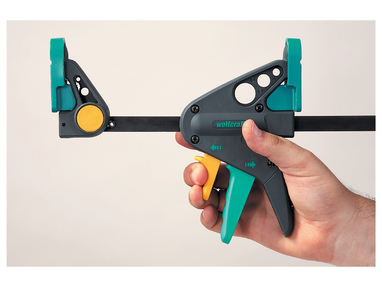 Un serre-joint Wolfcraft est tenu dans une main.