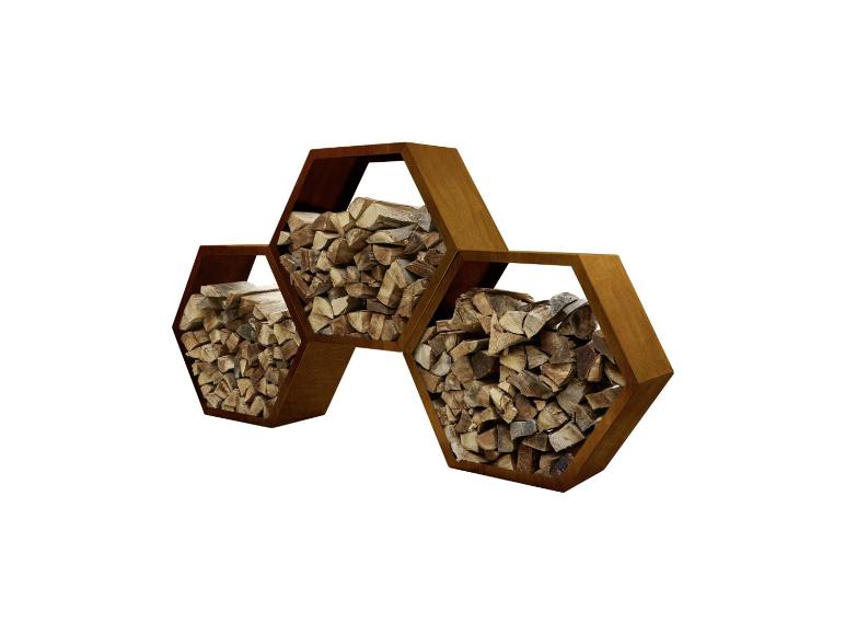 Trois porte-bûches hexagonaux en métal rouillé remplis de bois de chauffage.
