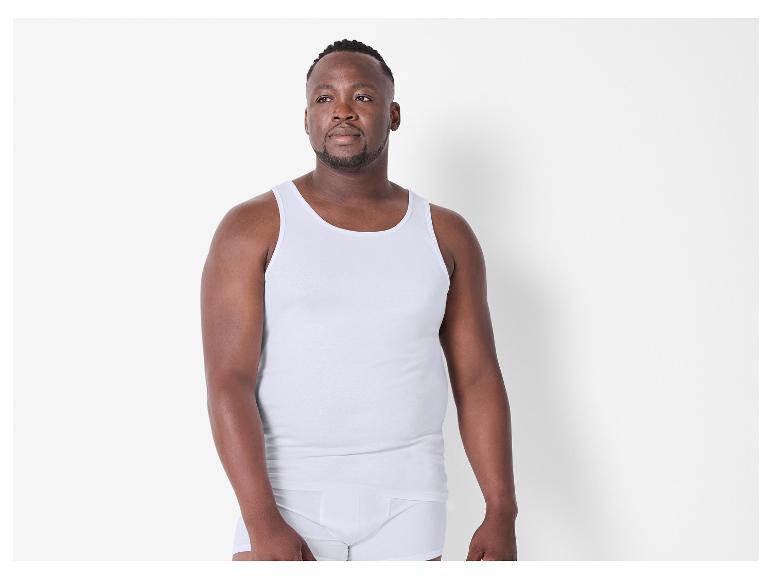 Homme en débardeur blanc et caleçon.