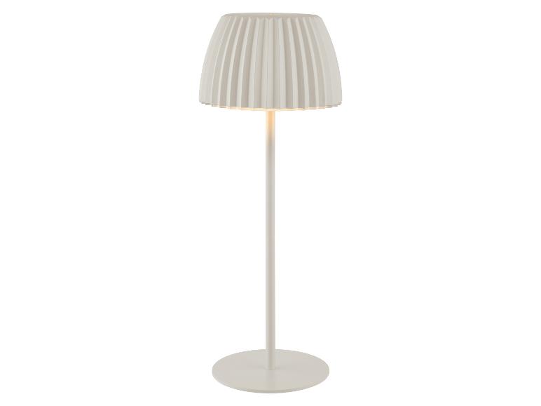 Lampadaire blanc avec un abat-jour plissé, émettant une lueur chaude.