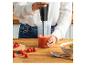 Femme préparant une soupe de tomates avec un mixeur plongeant dans la cuisine.